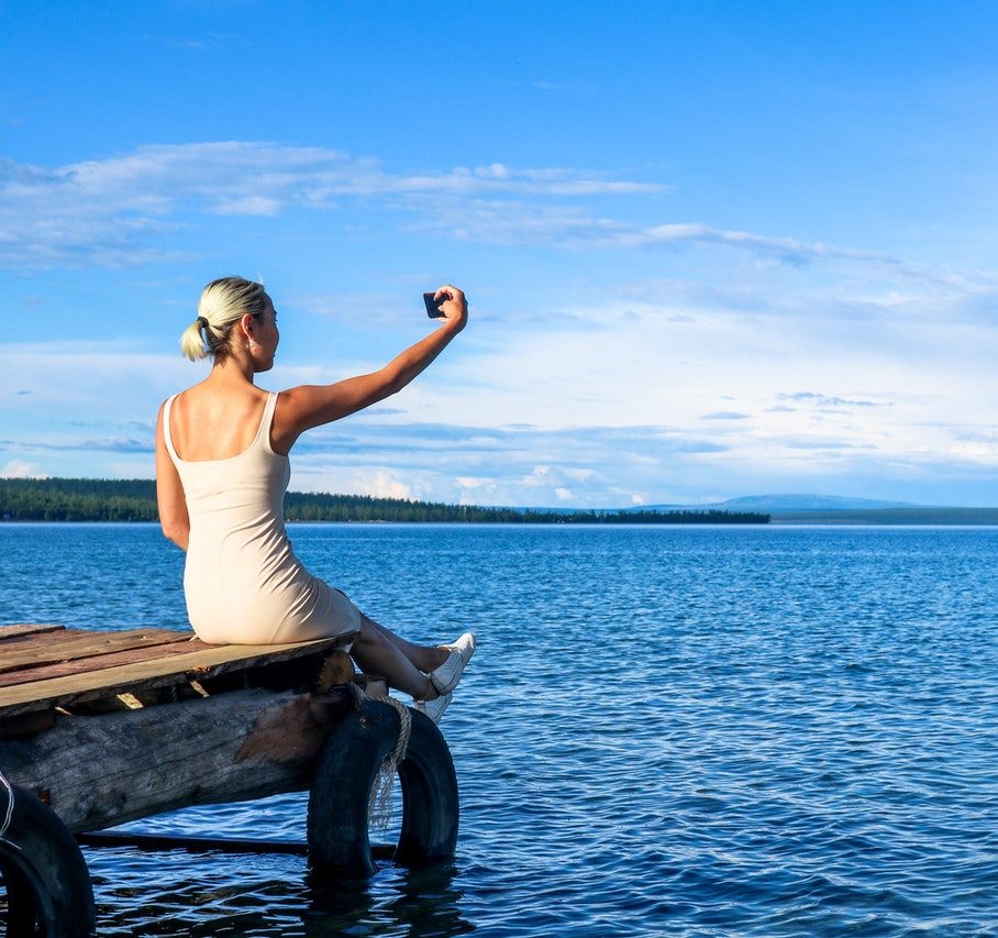 woman-taking-selfie-while-sitting-on-brown-dock-outdoor-1749855 (1)